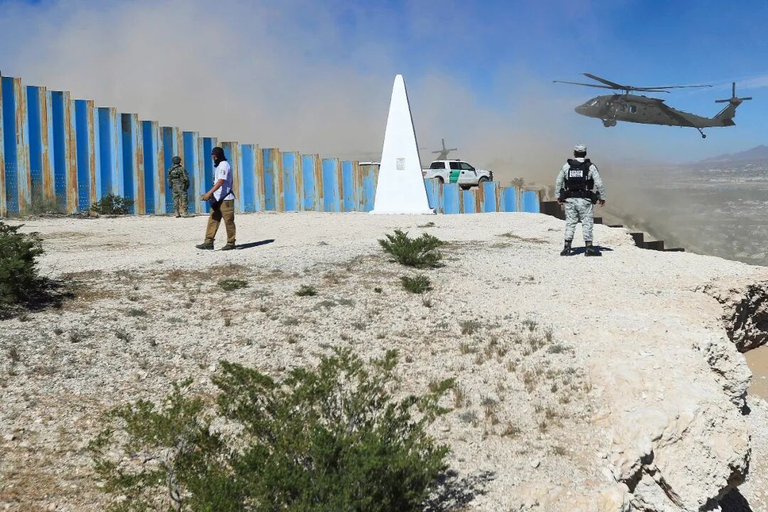 2025年11月7日,墨西哥边境城市华雷斯城,墨西哥士兵关注飞过的美国陆军直升机。