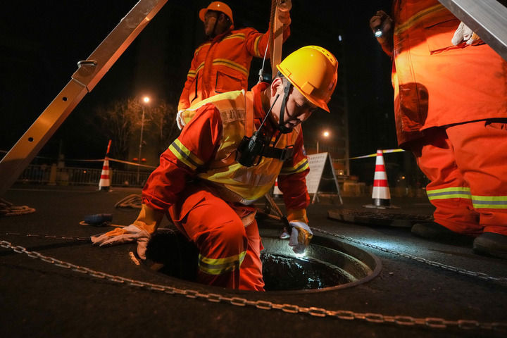 2月4日，韩朝阳（前）进入地下十一米深的热力井，带领班组进行管线巡查。新华每日电讯记者鞠焕宗 摄