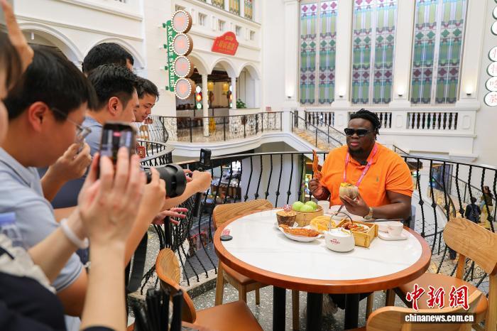 4月13日,尼日利亚籍主播博密(OLUWABUNMI HENRY JIMOH)在海口骑楼老街的椰城喜鹿老爸茶店里,用海南话向网友推介海南老爸茶。 中新网记者 骆云飞 摄
