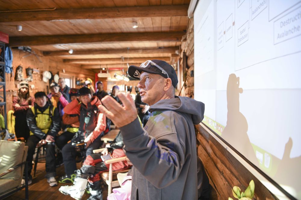 在新疆阿勒泰禾木吉克普林国际滑雪度假区，一名来自新西兰的滑雪专家向中外雪友分享雪崩风险管理等知识（2024年12月3日摄）。新华社记者 胡虎虎 摄