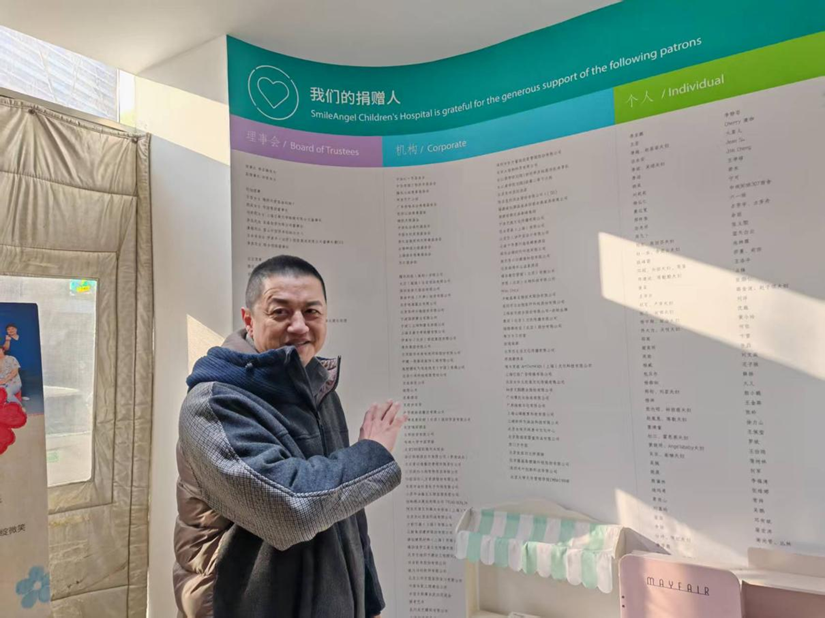 嫣然天使儿童医院一楼,李亚鹏在“我们的捐赠人”墙下介绍医院的诞生历程 图源:“公益时报”微信公众号