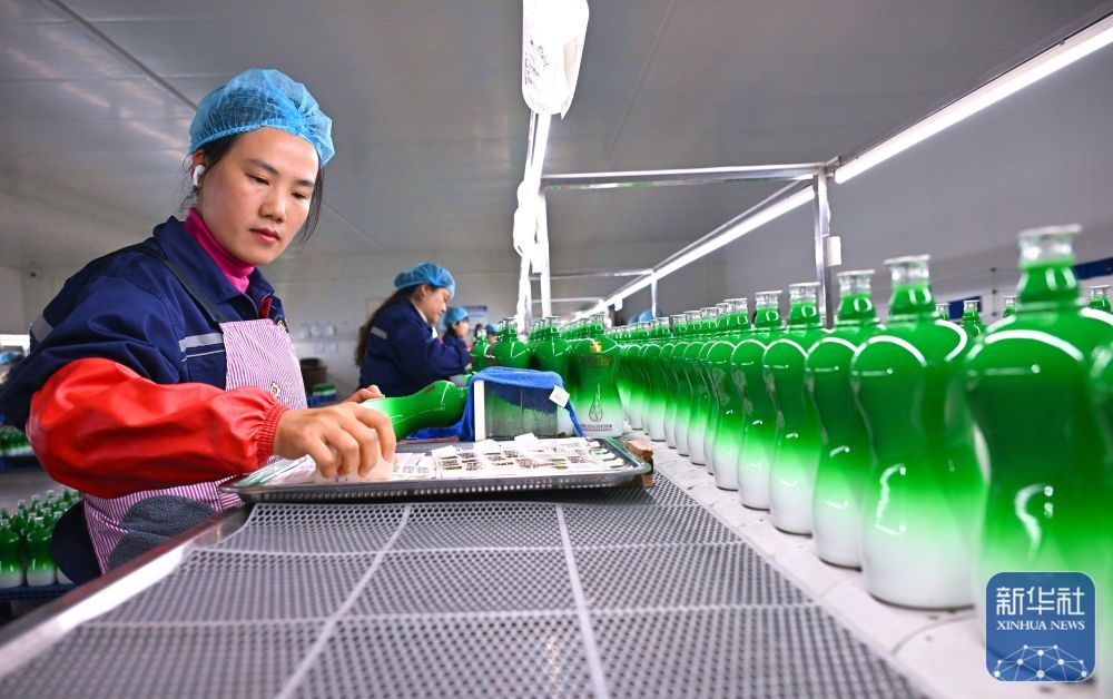 ↑ 2月24日,在位于四川省眉山市仁寿县汪洋镇的四川鑫盛昌水晶玻璃有限公司生产车间,工人在玻璃瓶上贴花。新华社发(潘建勇摄)