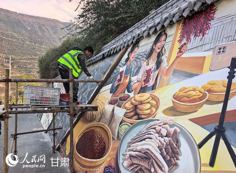 布楞沟的村道上,工作人员正站在脚手架上绘制彩绘墙。人民网记者 高翔