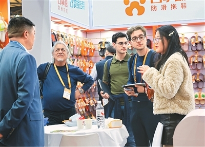 3月1日,第34届华东进出口商品交易会在上海新国际博览中心开幕,3300多家国内外企业参展。图为工作人员(右一)向采购商介绍产品信息。新华社记者 方 喆摄