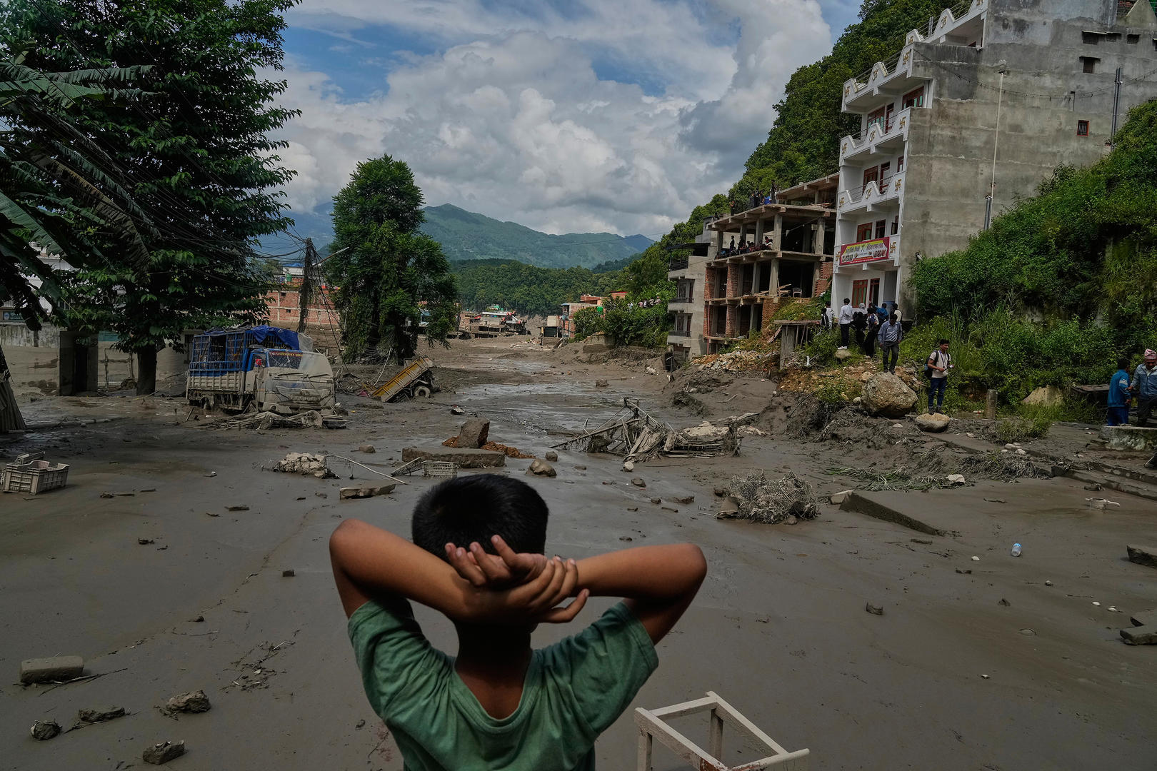 ▲当地时间2026年8月26日,尼泊尔努瓦果德地区,一名男孩看着特里苏里河洪水造成的破坏(图据视觉中国)