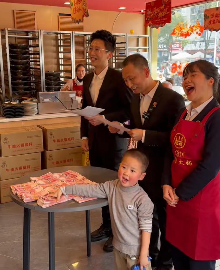 黄厚明(中)给员工发现金