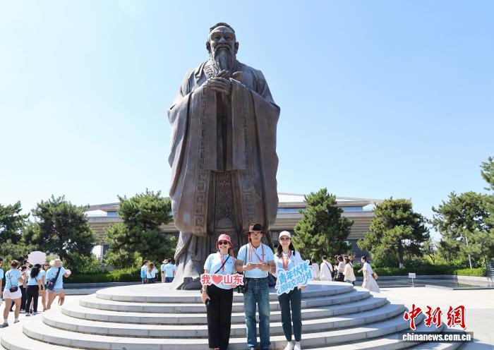 9月3日，美国青年在孔子像前合影留念。李明芮 摄