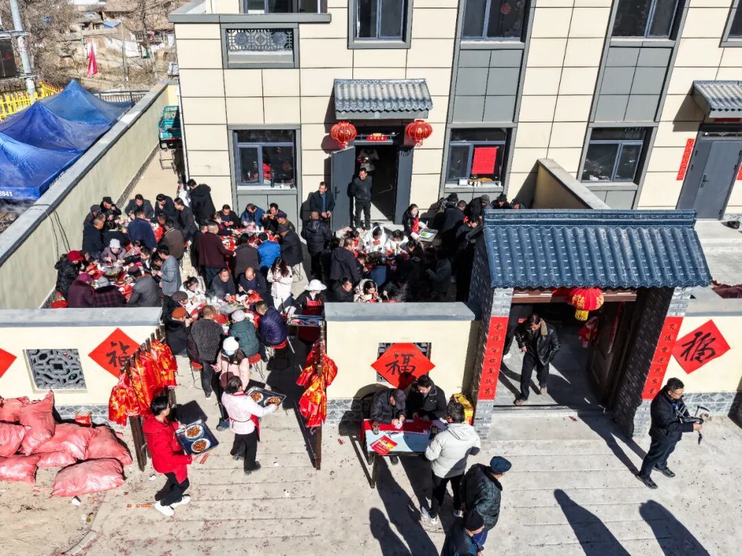 12月29日,村民在榆中县马坡乡马莲滩村集中安置点的新家里举办乔迁宴/无人机照片 图源:新华社