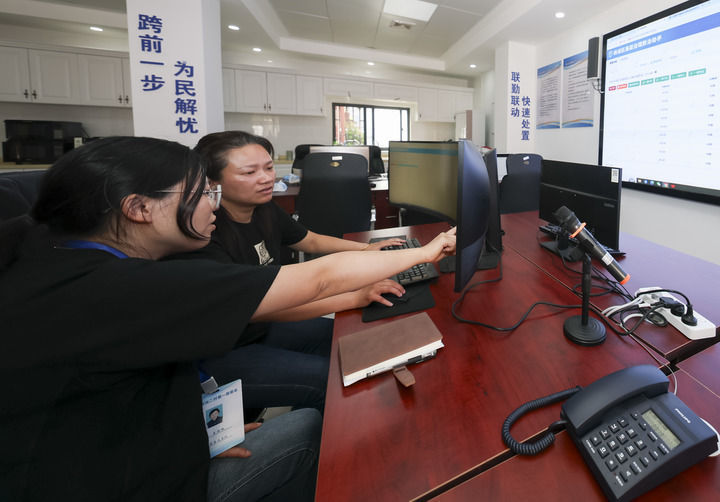 2025年5月12日，在上海市杨浦区殷行街道第五综合网格工作站，工作人员讨论通过“一键呼叫”与居民沟通。新华社记者 王翔 摄