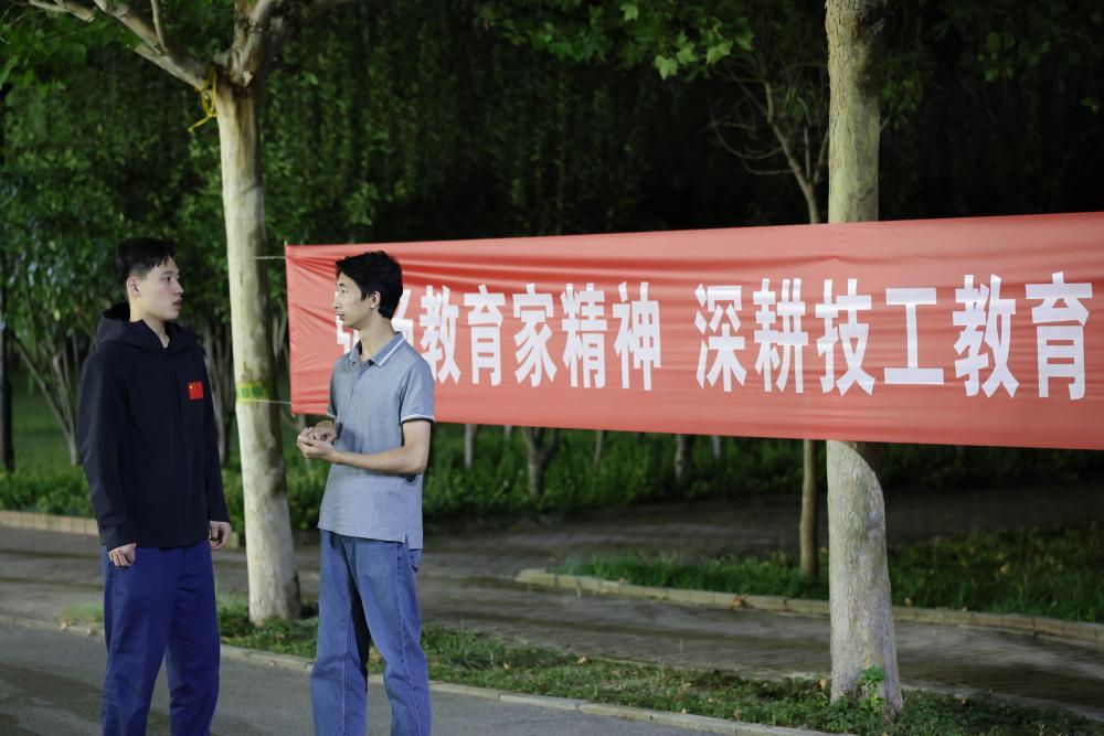9月11日,刘宇轩(左)和他的技术教练在校园内交流。