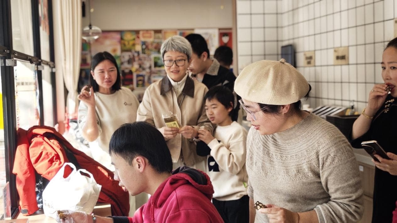 从国外回来的顾客专门带着礼物看望星青年们（记者江晓晨 摄）