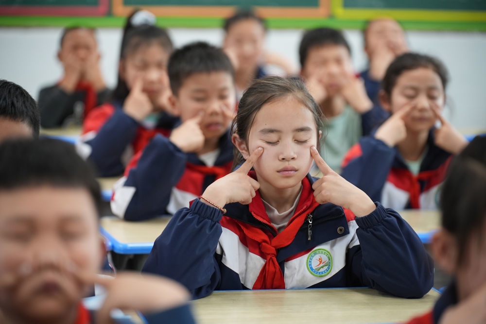 图为陕西安康市平利县老县镇中心小学学生在教室内做眼保健操。新华社记者 邵瑞 摄
