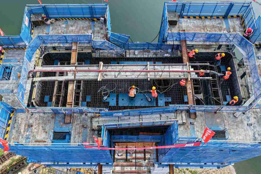 8月21日,中铁十一局承建的G331国道拉古哨至浑江口段大久才江口特大桥主塔全部封顶,这是工人在进行混凝土浇筑作业(无人机照片)。新华社发(中铁十一局供图)