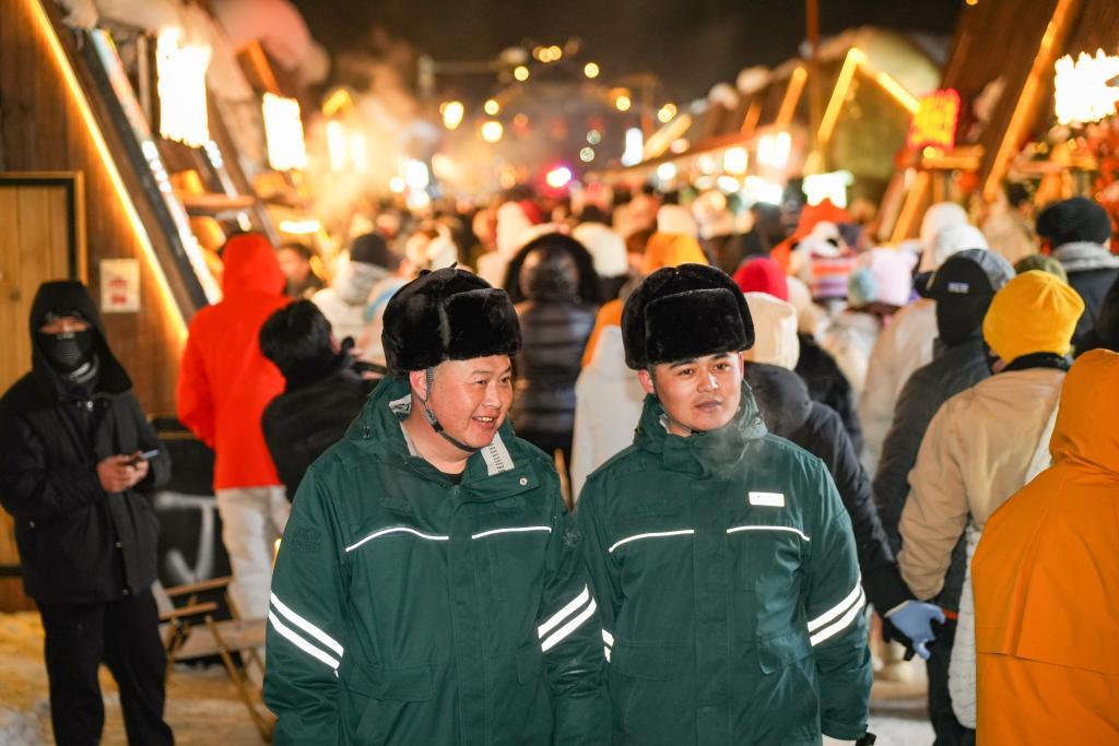 禾木供电所所长齐凡与同事哈依沙尔&middot;胡安汗在禾木夜晚街道巡查用电安全。新华社记者徐宏岩 摄