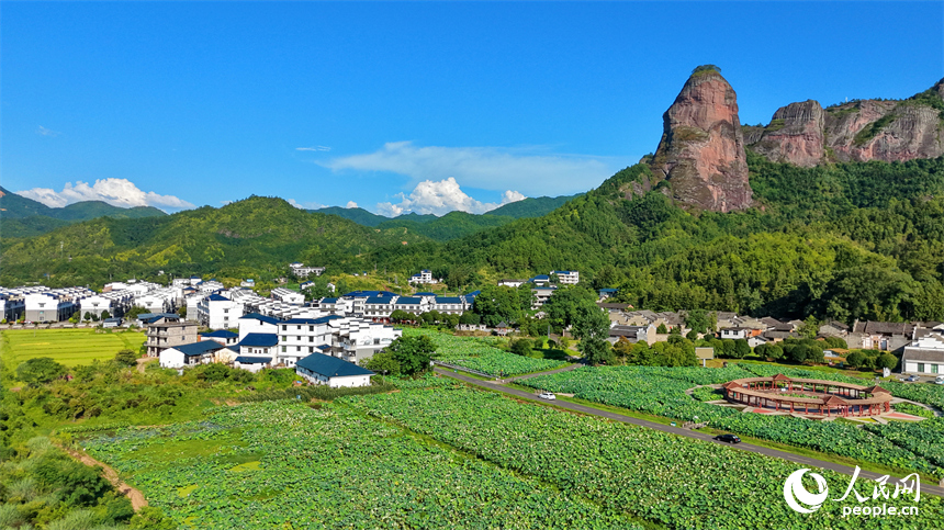 石城县琴江镇大畲村，一栋栋民居错落分布于青山田园间，与丹霞峰峦、青翠沃野相互映衬。人民网记者 朱海鹏摄