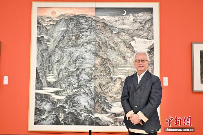 2025年11月，“江山万里心——林章湖水墨回顾展”在中国美术馆举行。图为林章湖在展览现场和其画作《问道灵山》合影。　中新社记者 徐雪莹 摄
