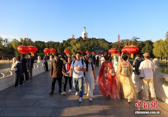 10月5日,国庆假期,北京北海公园游人如织。图为游客走过公园内的永安桥。中新社记者 贾天勇 摄
