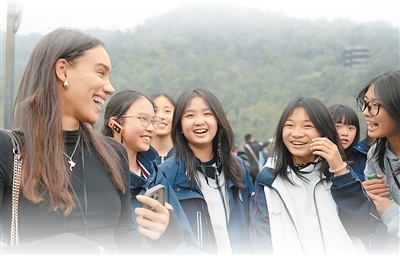 考察团成员梅里顿（左一）在都江堰景区与当地学生交谈。陈春安摄