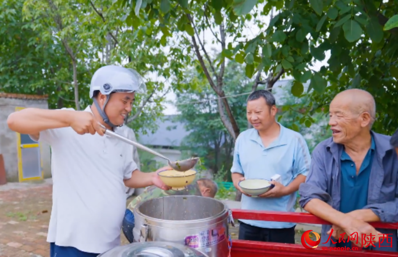 庞富强正在给老人盛饭。人民网 王丽摄