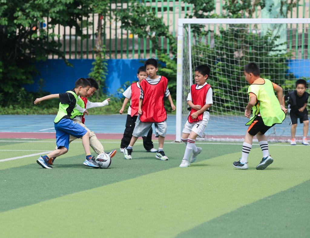 5月28日,嘉兴市南湖区秀城实验教育集团吉水小学学生在操场上踢足球。新华社记者 徐昱 摄