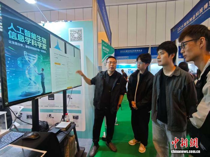 1月15日，在三亚国际种业科学家大会国际种业科技博览会上，海南大学三亚南繁研究院副院长夏志强(左一)向观众介绍“人工智能生物信息学科学家系统”。　张月和 摄