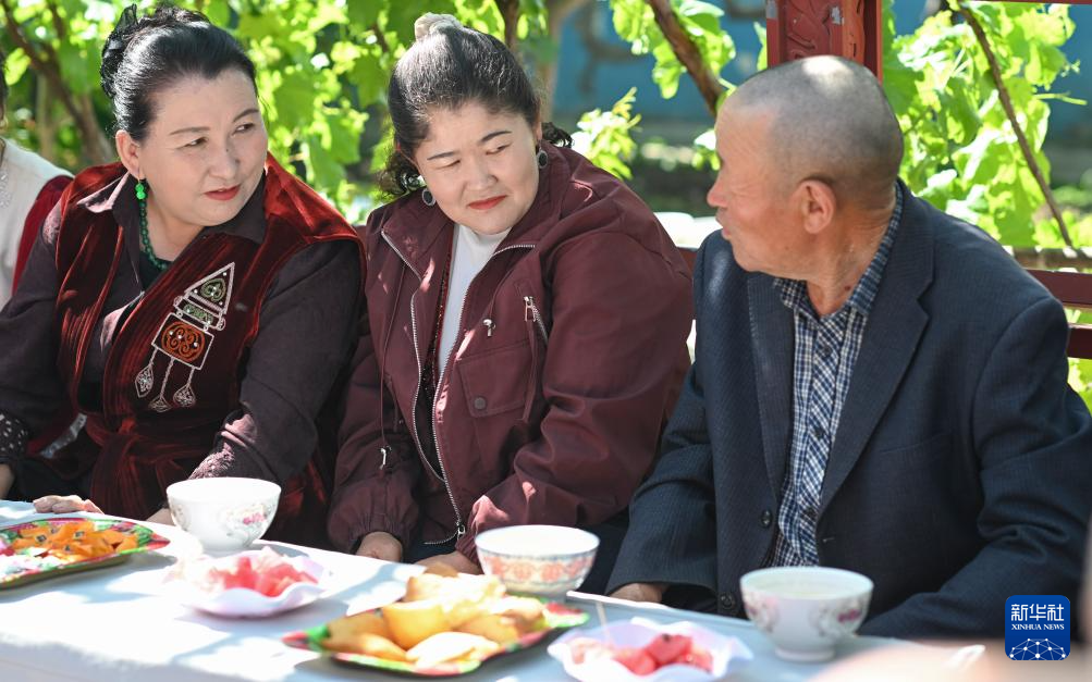 村民在新疆伊宁县喀拉亚尕奇乡喀拉亚尕奇村“伊犁人的奶茶会”上交流（5月14日摄）。