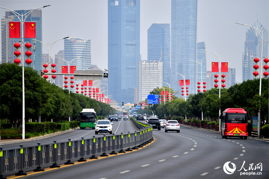 南昌市红谷滩区的道路两侧悬挂着崭新的国旗，城市洋溢着喜庆祥和的节日氛围。人民网记者 时雨摄