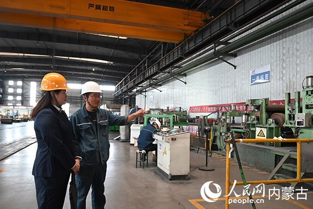 包头威丰新材料有限公司生产主任贾建锋(左二)正在给工商银行内蒙古包头稀土高新技术产业开发区支行工作人员介绍生产流程。人民网记者 刘艺琳摄
