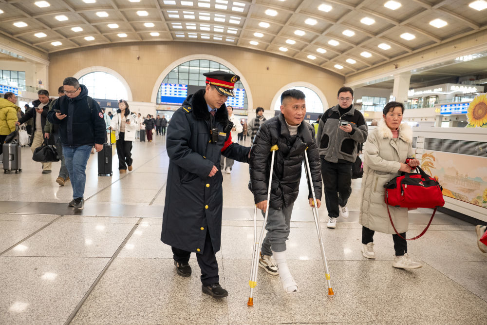 2026年2月2日，湖北省武汉市汉口火车站工作人员帮助旅客进站乘车。新华社记者 肖艺九 摄