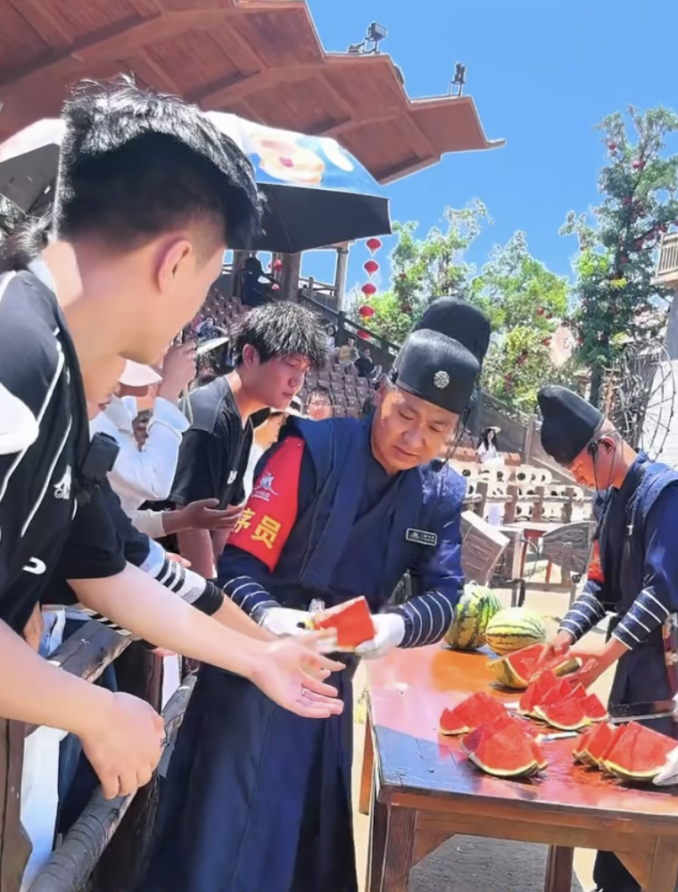 △万岁山武侠城工作人员给游客发西瓜
