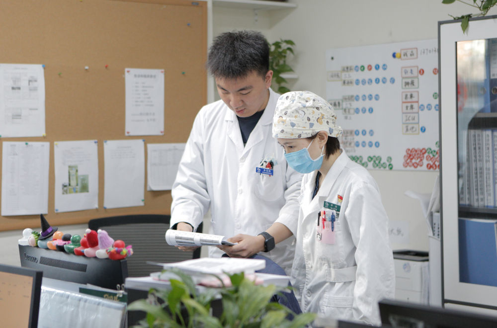 2月9日9时许，急诊科主治医师李琼（右）与学生在办公室进行业务交流。