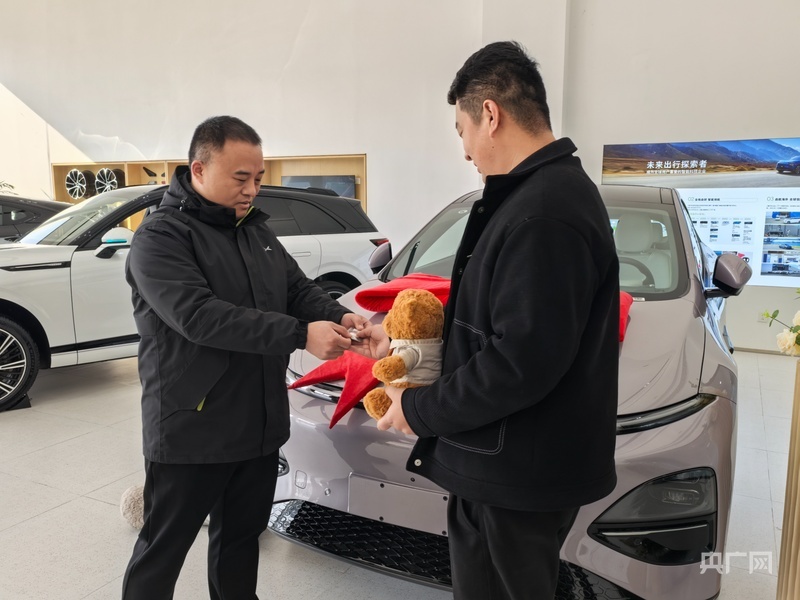 在新能源汽车4s店内，消费者张先生喜提爱车（央广网记者 刘佳音 摄）