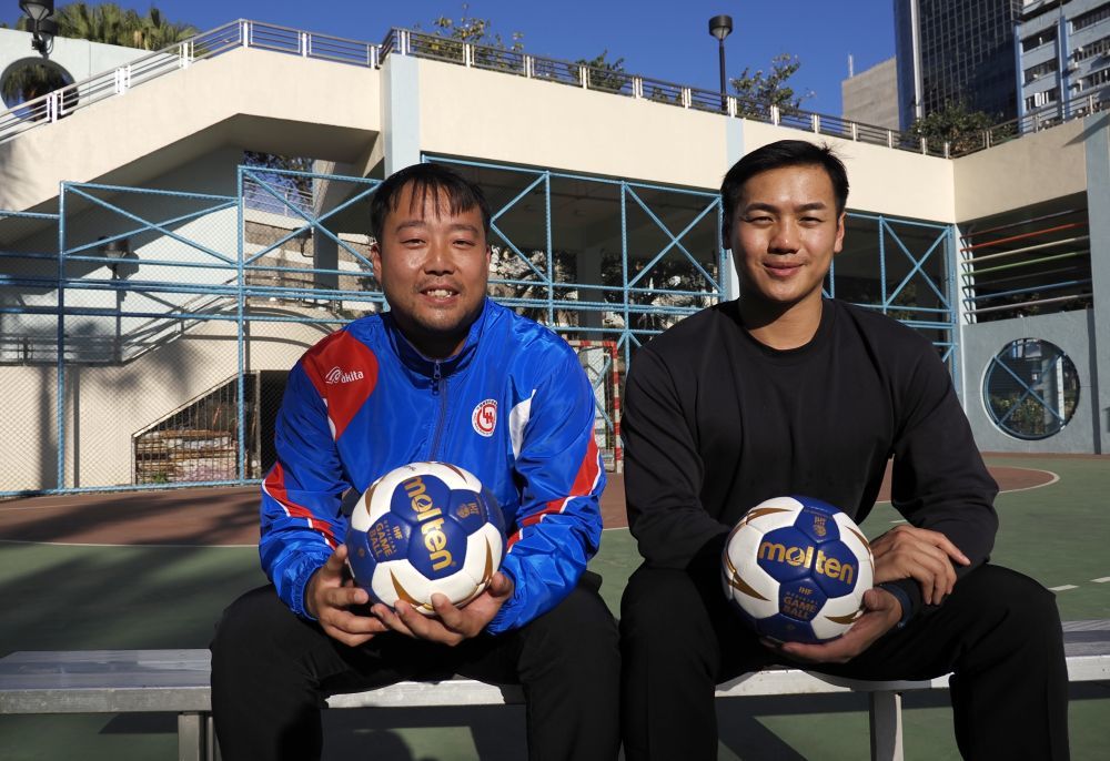 在香港新蒲岗彩虹道150号的露天游乐场，香港男子手球队主教练许文邦（左）和队长谢永辉一起接受记者拍照（2025年12月17日摄）。新华社发（王申摄）