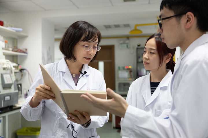 陈玲玲(左一)在中国科学院分子细胞科学卓越创新中心实验室和学生们交流(2022年8月11日摄)。新华社记者 金立旺 摄