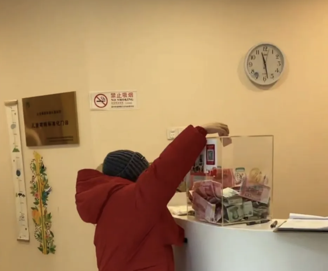 爱心人士向嫣然儿童医院内的捐款箱捐款。