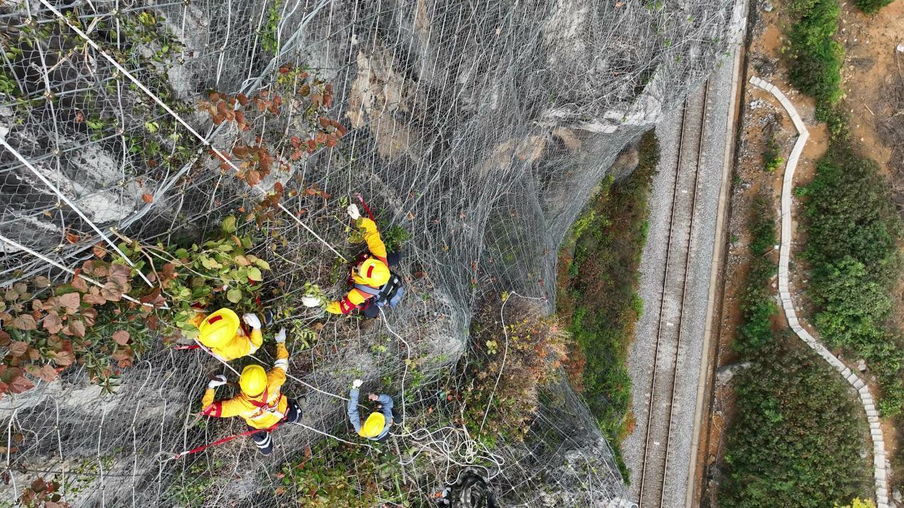 杨发登和队员“挂”在崖壁上检查危石