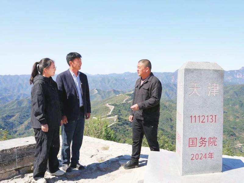 10月1日,北京市平谷区金海湖镇红石门村党支部书记胡杰(左)、天津市蓟州区下营镇前干涧村党支部书记张雪松(中)和河北省兴隆县陡子峪乡前干涧村党支部书记闫凤龙在京津冀三界碑旁相聚,共同商量三个村怎样抱团发展得更红火。 河北日报见习记者 崔玉洁 摄