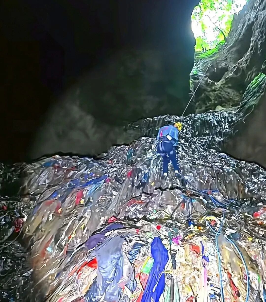 符正下到溶洞内查看里面堆积的垃圾