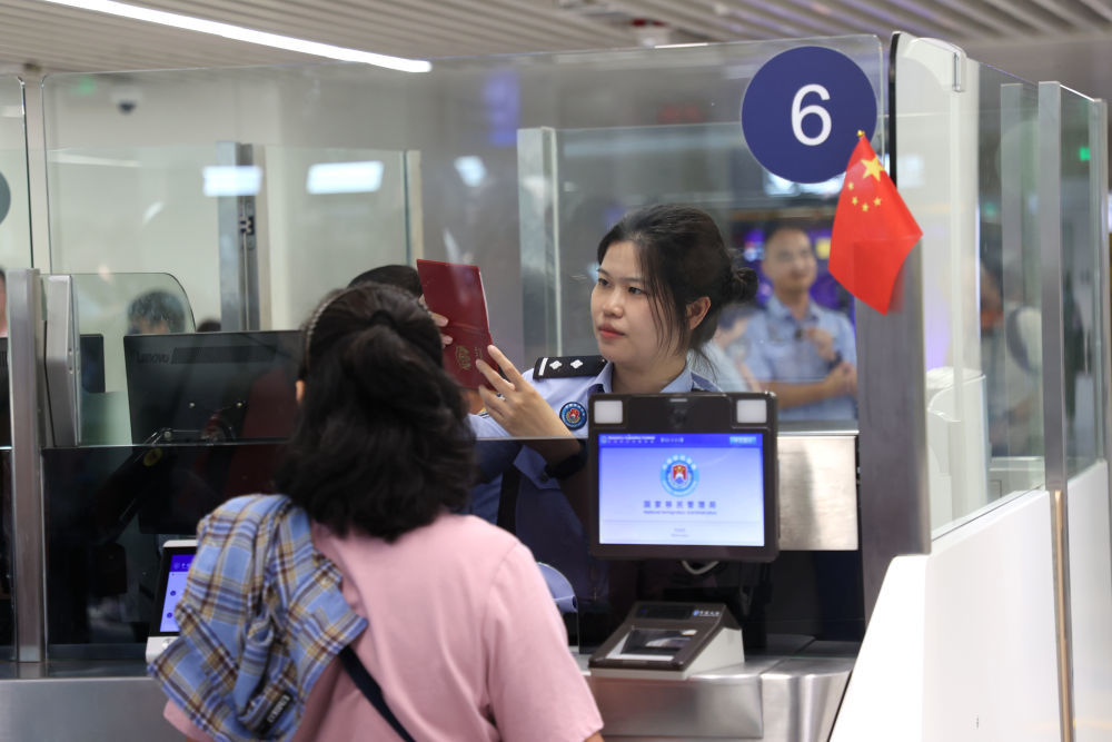 2026年3月27日,海口美兰边检站执勤民警为入境旅客办理边检手续。(新华社发)