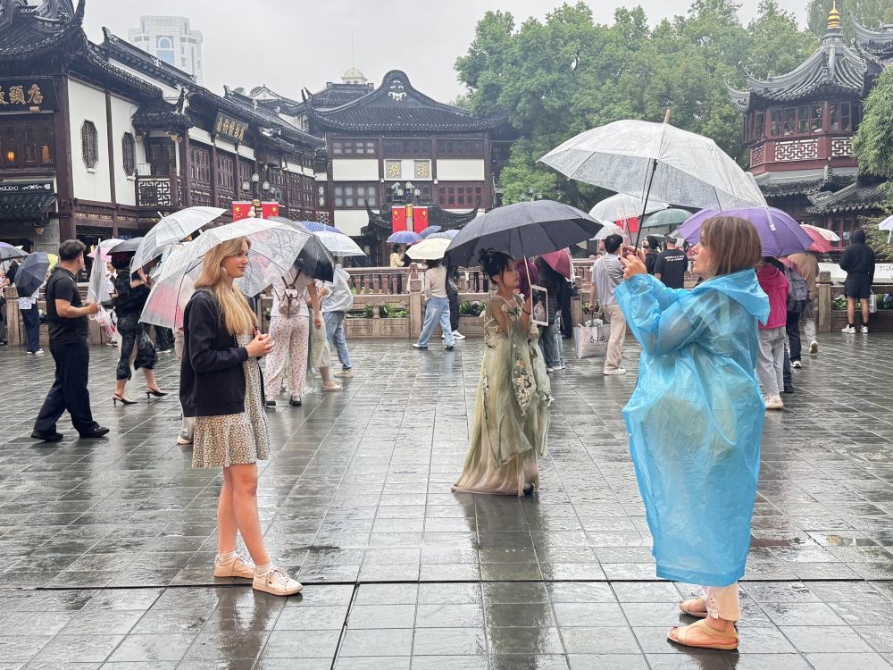 国庆假期，外国游客在上海豫园雨中游览拍照。新华社记者 戚新源 摄