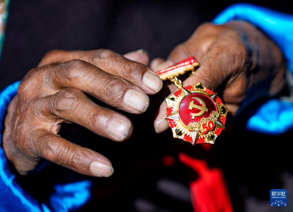 白玛扎西在家中擦拭“光荣在党50年”纪念章（3月26日摄）。