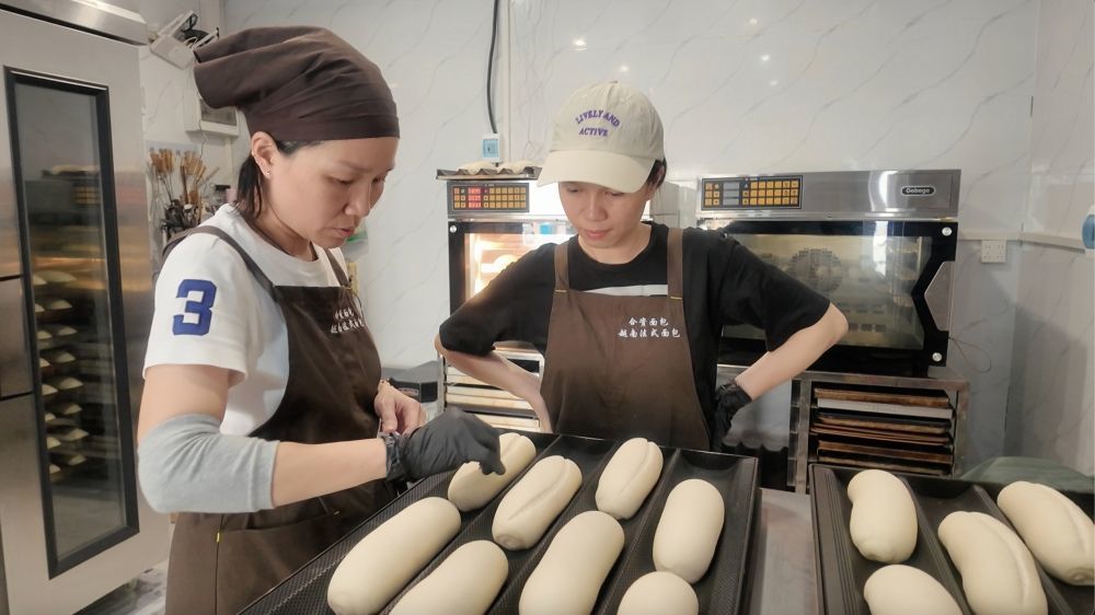 ↑武碧玉在指导店员割包。(刘樱涵 摄)