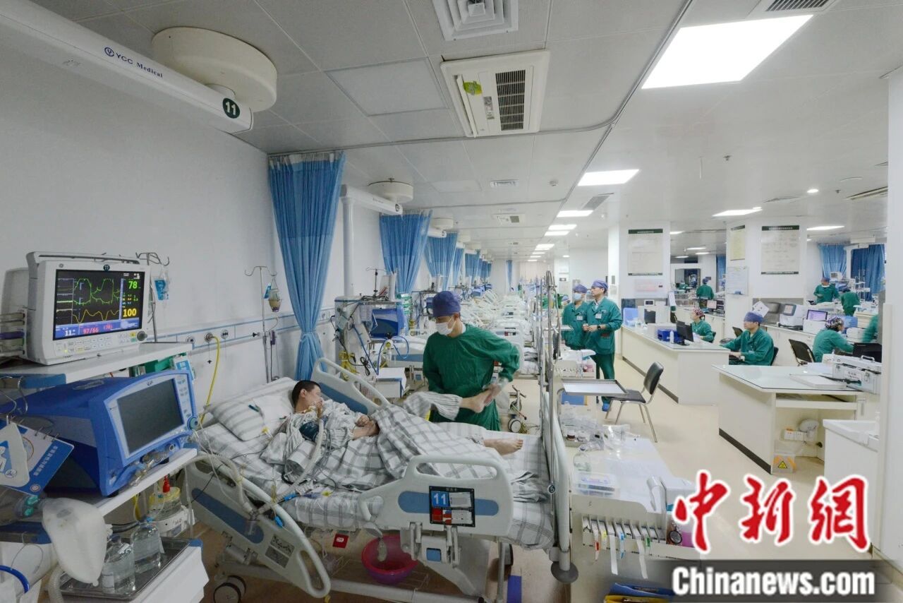 一天夜里，福建医科大学附属协和医院重症监护室护士周强龙(左一)正在为患者锻炼下肢。受访者 供图