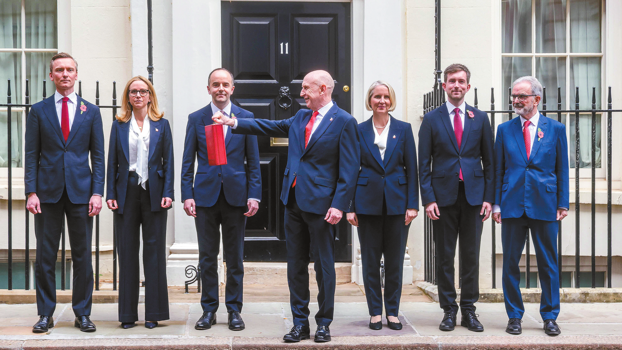英国财政大臣希利(中)28日离开唐宁街10号,准备前往议会下院公布新政府首份财政预算案。(视觉中国)