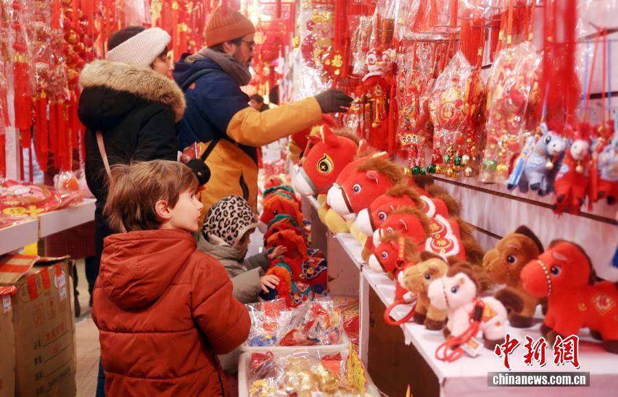 2026年2月11日，上海，位于豫园老城厢的旅游商品市场吸引外国游客，家长带孩子乐购春节年货。中新社发 陈玉宇 摄