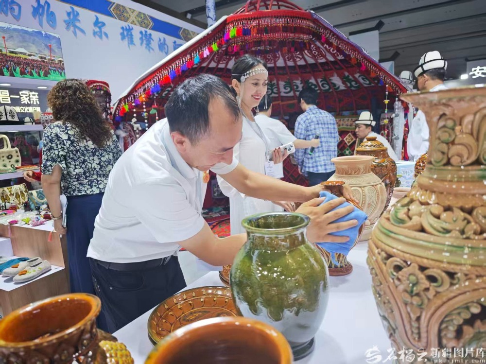 奥布力塔力普认真擦拭展品。天山网-新疆日报记者 宋海波 摄