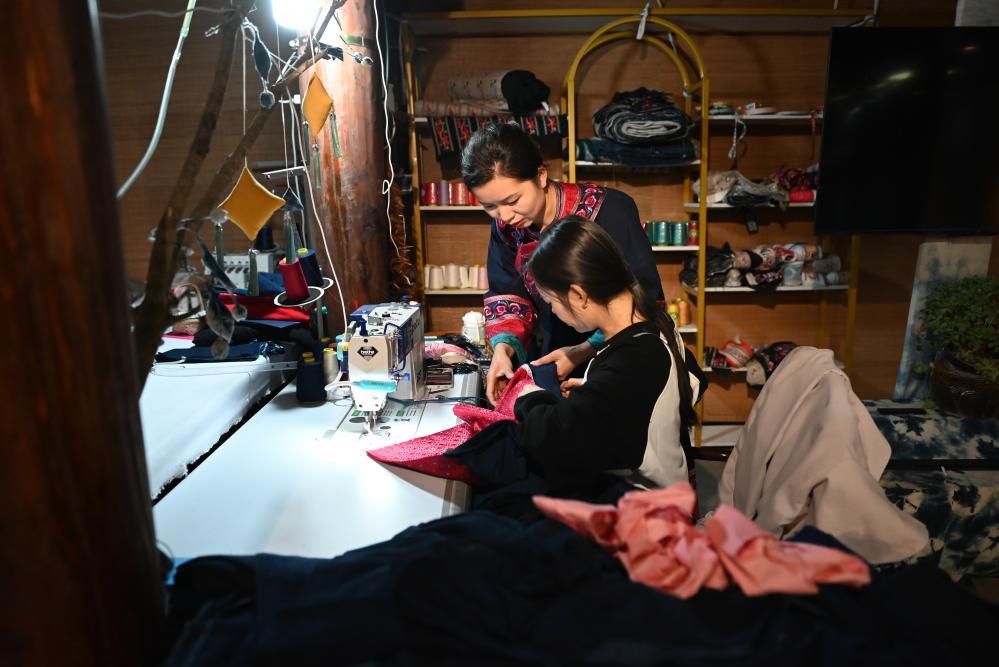 李利（后）在贵州省兴义市万峰林景区门店内与员工一起制作民族服饰（2024年2月19日摄）。新华社记者 刘续 摄