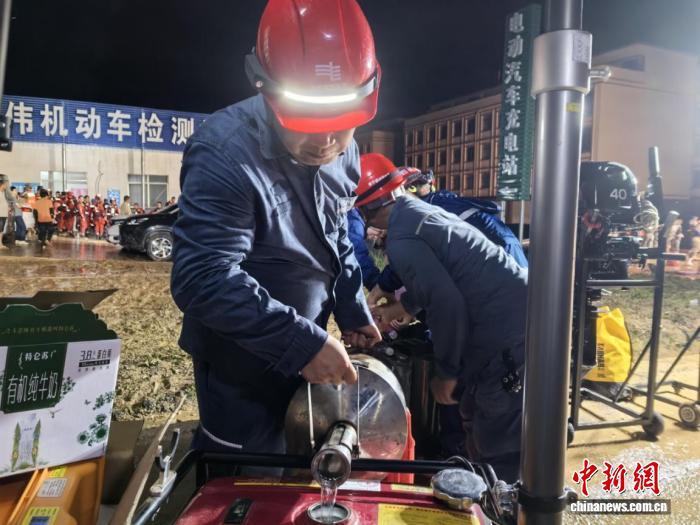7月6日晚,南方电网广西南宁横州供电局工作人员给照明灯添加油料。农秀凤 摄