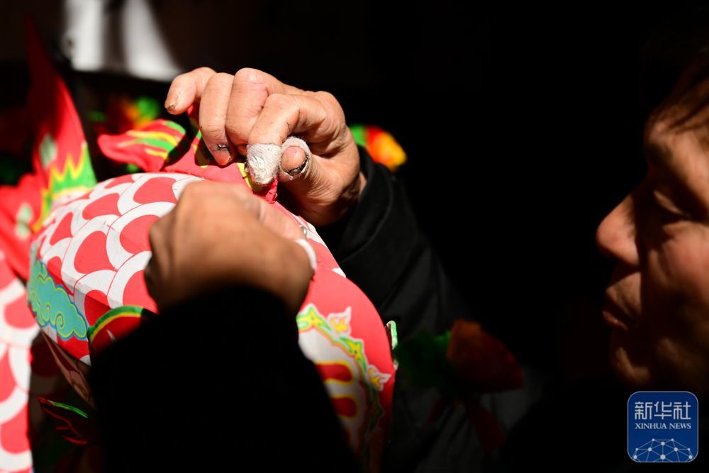 2月8日,瞻淇村的市级非遗项目鱼灯代表性传承人汪近午在制作鱼灯。他的手指因长年制作鱼灯而缠上了胶布。