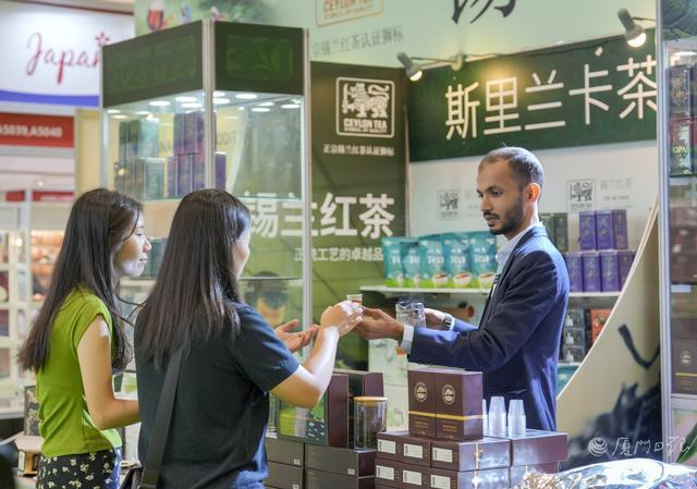 “斯里兰卡茶叶局”摊位上,商家给顾客介绍茶的特点。